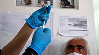 Une infirmière s'apprête à réaliser une injection du vaccin anticovid Pfizer à un homme sur l'île d'Iraklio, en Grèce, le 13 mai 2021