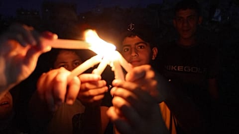 Children holding and lighting candles