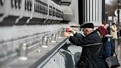 Elderly people light candles at the Wall of Heroes outside the House of Terror Museum to pay their tribute on the occassion of the Memorial Day of Victims of Communism.