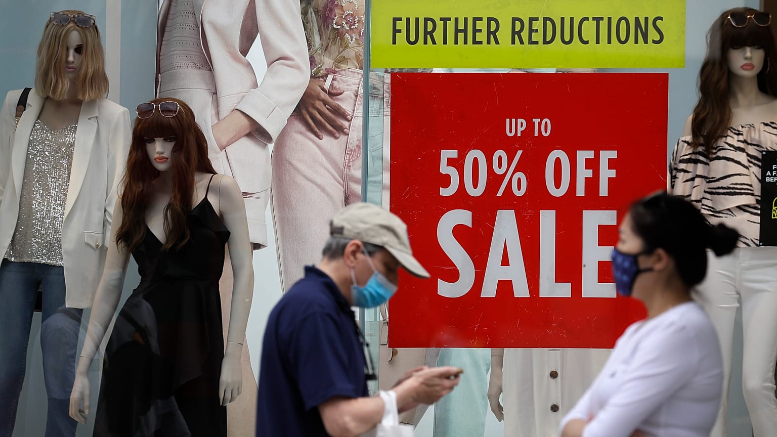 Shoppers pass a sale sign in a shop window on Oxford Street in London, Aug. 13, 2020. 