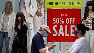 Shoppers pass a sale sign in a shop window on Oxford Street in London, Aug. 13, 2020. 