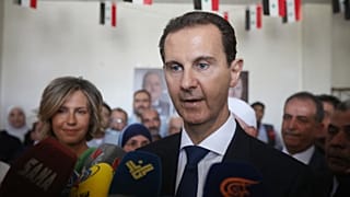 الرئيس السوري بشار الأسد وزوجته أسماء يدليان بصوتيهما في مركز اقتراع في دوما بالقرب من دمشق في 26 مايو 2021.