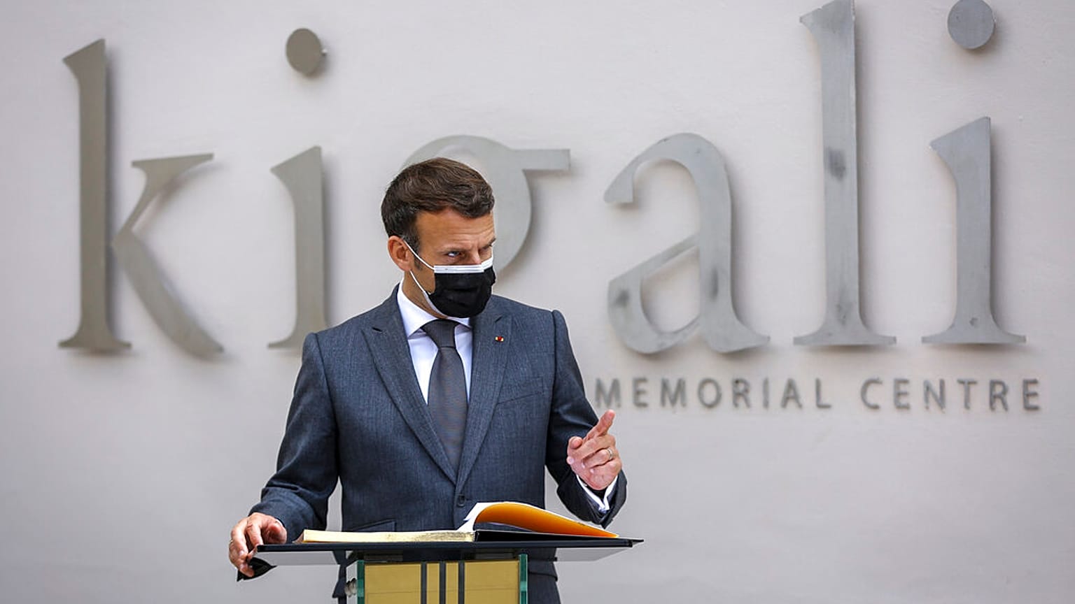 French President Emmanuel Macron speaks next to the visitor's book at the genocide memorial site in the capital Kigali, Rwanda 