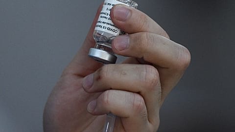 A health worker holds a vial of the AstraZeneca/Oxford Covid-19 coronavirus vaccine inside a Catholic church turned into a vaccination centre in Manila on May 21, 2021.