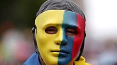 Un manifestante cubre su rostro con una máscara con los colores de la bandera colombiana en Bogotá, el 26 de mayo de 2021.