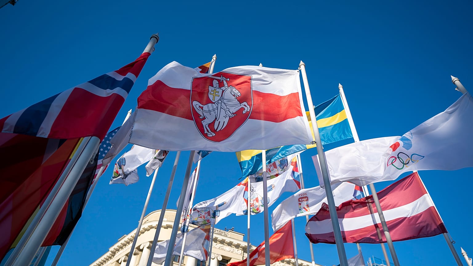Бело-красно-белый флаг среди символики участников Чемпионата мира по хоккею в Риге