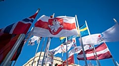 Бело-красно-белый флаг среди символики участников Чемпионата мира по хоккею в Риге