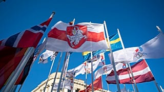 Бело-красно-белый флаг среди символики участников Чемпионата мира по хоккею в Риге