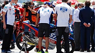 Teammates of 19 years-old Swiss racer Jason Dupasquier by his motorbike during a minute's silence on Sunday