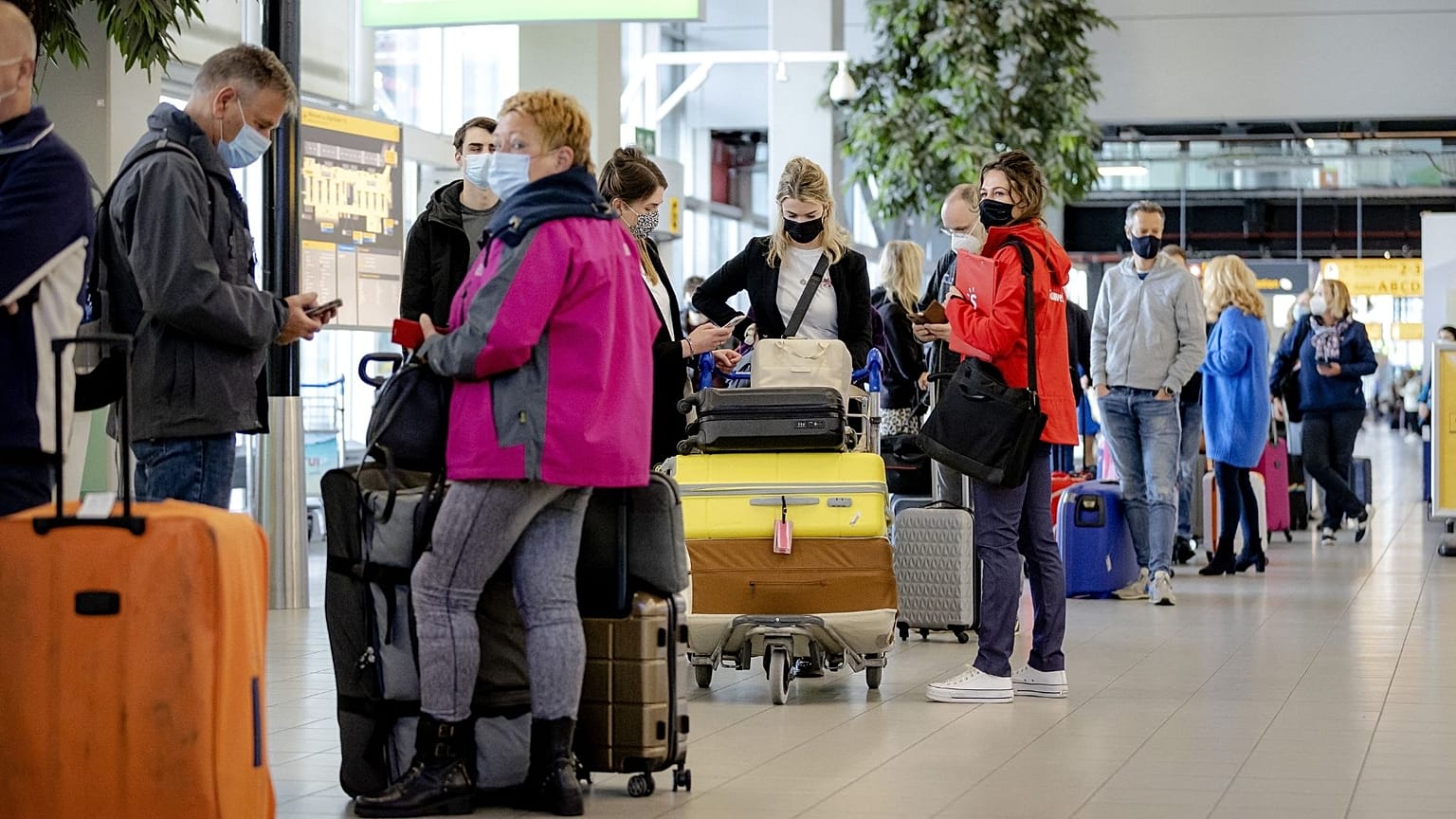 Travellers stand in an airport in the Netherlands