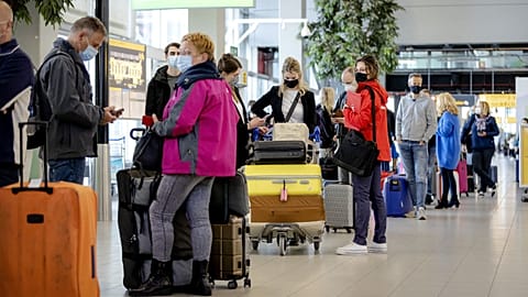 Travellers stand in an airport in the Netherlands