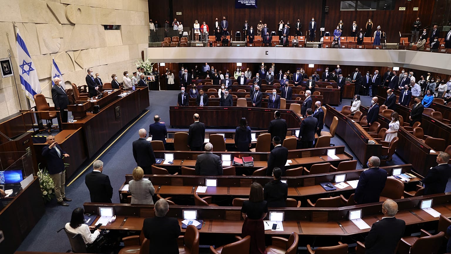 نواب إسرائيليون يقفون خلال مراسم أداء اليمين للكنيست (البرلمان) الإسرائيلي في القدس 6 أبريل 2021.