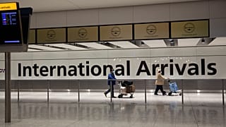 Arriving passengers walk past a sign in the arrivals area at Heathrow Airport in London, on Jan. 26, 2021.