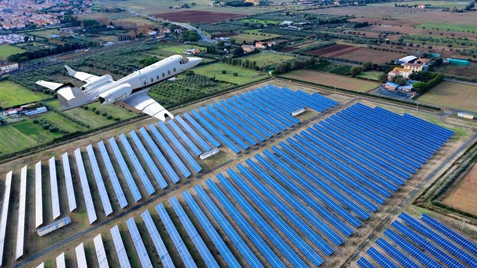 Un avión volando sobre una central solar