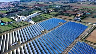 Flugzeug überfliegt ein Feld mit Solaranlagen