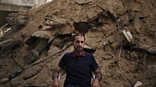 عزام الكولك يجلس امام انقاض بيته المدمر في غزة. 2021/05/31