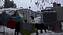 FILE: A Syrian refugee man clears the snow around his shelter at the refugee camp of Ritsona about 86 kilometres north of Athens, Wednesday, Jan. 11, 2017. 