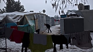 FILE: A Syrian refugee man clears the snow around his shelter at the refugee camp of Ritsona about 86 kilometres north of Athens, Wednesday, Jan. 11, 2017. 