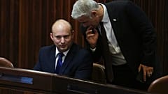 Líder do Yamina, o nacionalista Naftali Bennett, sorri com as palavras de Yair Lapid, líder Yesh Atid
