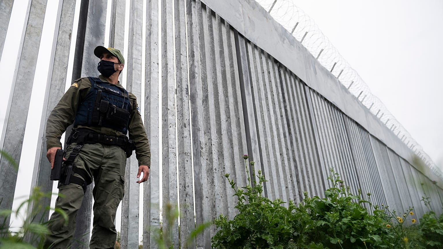 A police officer patrols alongside a steel wall at Evros river, near the village of Poros, at the Greek -Turkish border, Greece