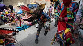 Personas vestidas con trajes de diablo celebran la fiesta católica del Corpus Christi en Naiguatá, Vargas, Venezuela, el 3 de junio de 2021.
