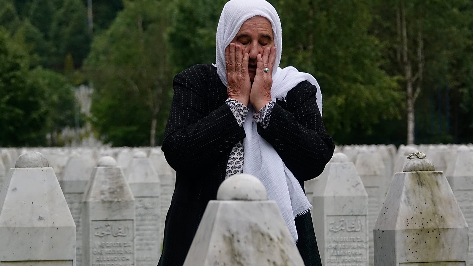 Munira Subasic who lost her son and the husband in Srebrenica massacre prays at the memorial cemetery in Potocari near Srebrenica, Bosnia, Friday, May 28, 2021.