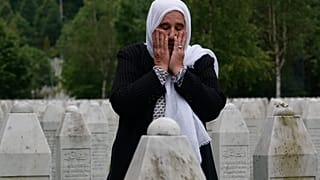 Munira Subasic who lost her son and the husband in Srebrenica massacre prays at the memorial cemetery in Potocari near Srebrenica, Bosnia, Friday, May 28, 2021.