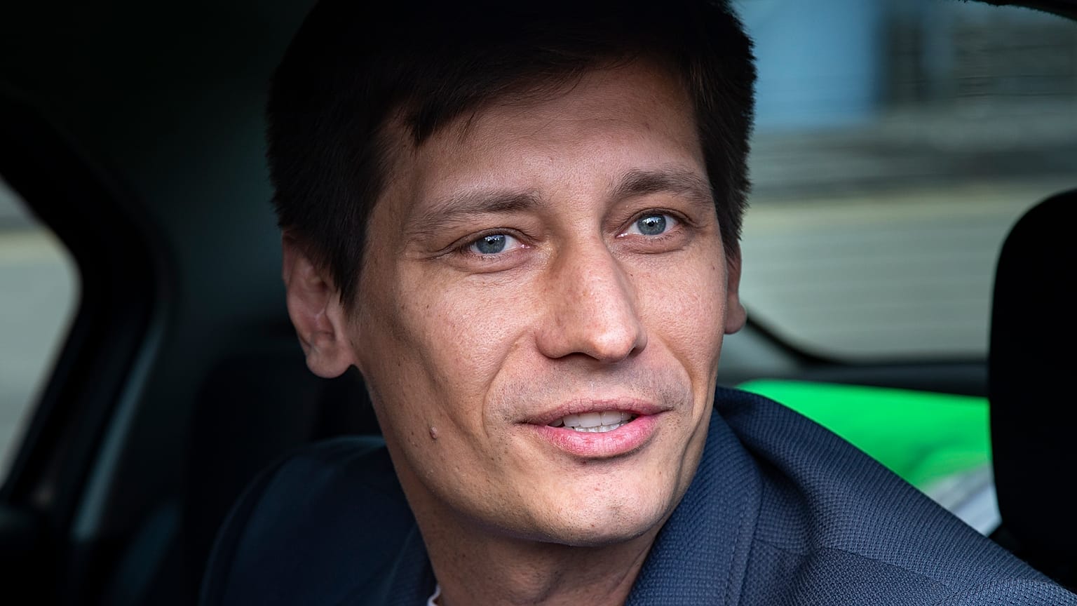 In this Tuesday, July 30, 2019 file photo, Russian opposition candidate Dmitry Gudkov speaks to journalists sitting inside a police car as he arrives to the court in Moscow.