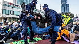Police remove environmental activists of Extinction Rebellion group (XR) as they block one of the main streets in the city centre to draw attention to the climate crisis.