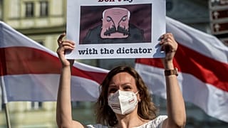 A woman holds a placard with the lettering 'Don't fly with the dictator' during a 'Together for Belarus' rally against Belarusian President Lukashenko
