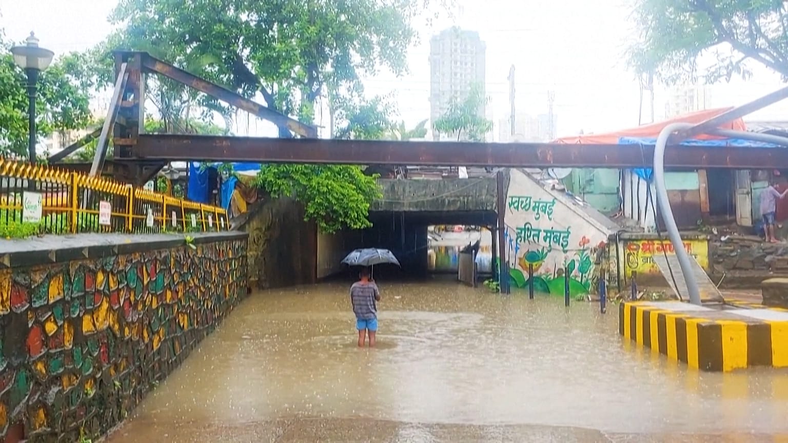 A resident wades through his waterlogged building