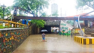 A resident wades through his waterlogged building