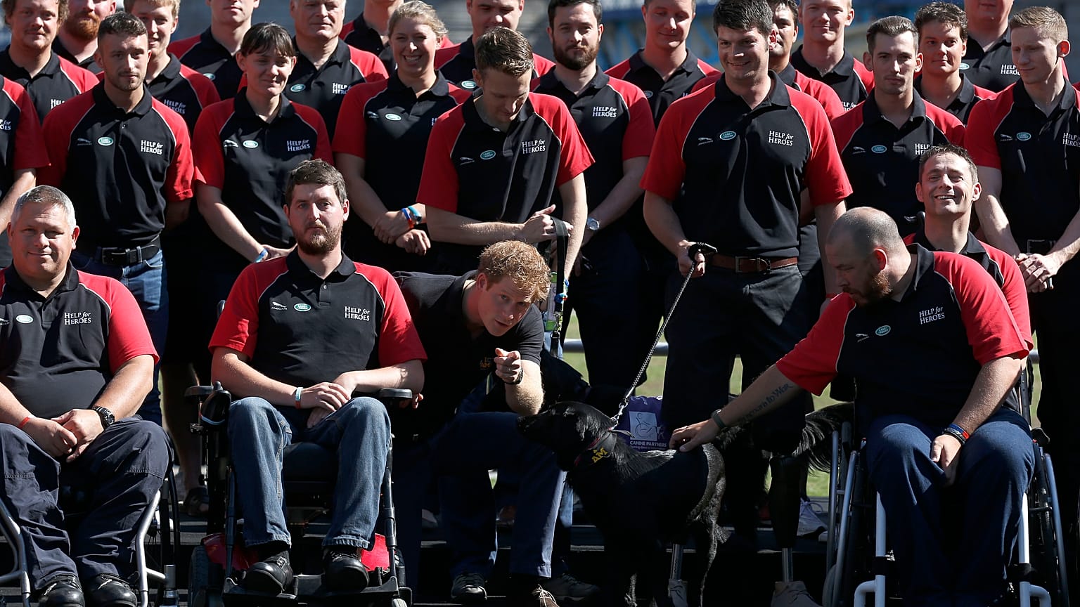 FILE - Britain's Prince Harry poses with the team during the announcement of the British Armed Forces team for the Invictus Games in London, Wednesday, Aug. 13, 2014