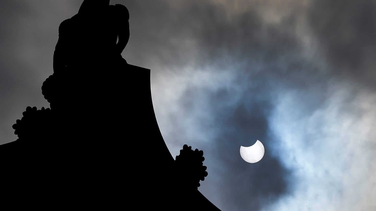 The partially eclipsed sun beside Nelson's Column in Trafalgar Square in London, Thursday, June 10, 2021. 