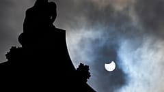 The partially eclipsed sun beside Nelson's Column in Trafalgar Square in London, Thursday, June 10, 2021. 
