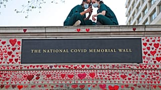 Londra, giugno 2021: infermiere dell'ospedale St Thomas riposano sul muro del memoriale nazionale per le vittime di Covid