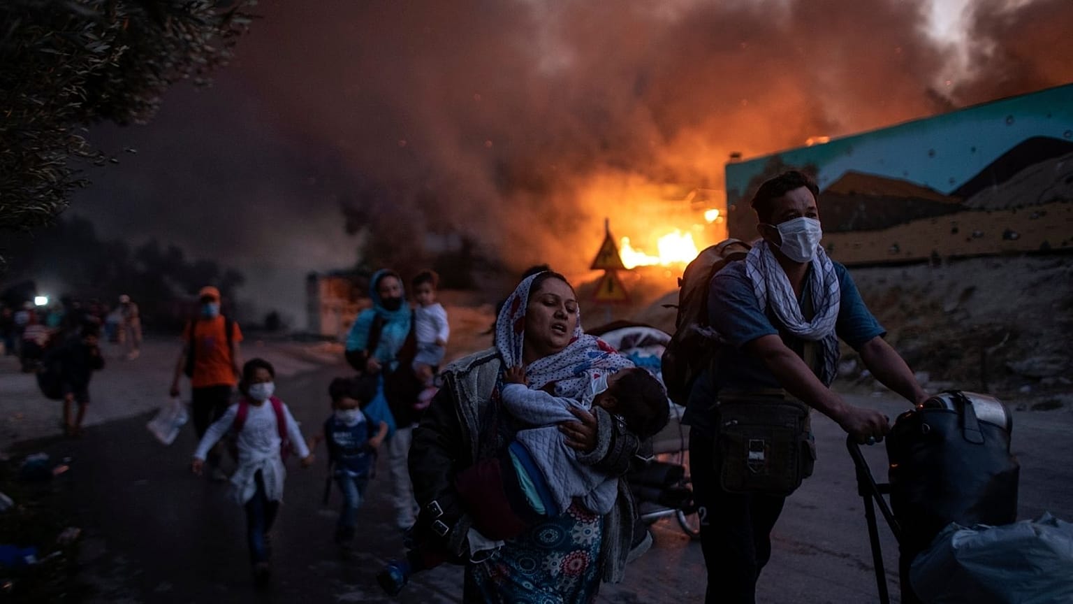 migrants flee from the Moria refugee camp during a second fire