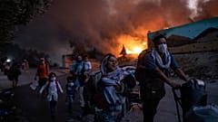 migrants flee from the Moria refugee camp during a second fire