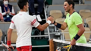 Serbia's Novak Djokovic, left, shakes hands with Spain's Rafael Nadal after their French Open semifinal, Paris, June 11, 2021. Djokovic won 3-6, 6-3, 7-6 (4), 6-2.