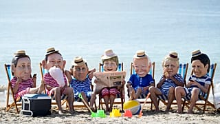 Activistas climáticos de Oxfam, con cabezas gigantes que representan a los líderes del G7 en la playa de Swanpool en Falmouth, Cornualles, Inglaterra, el 12 de junio de 2021.