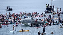Paddleboarders and surfers take part in a paddle out to raise awareness for climate action in the sea at Gyllyngvase Beach in Falmouth, Cornwall, England, June 12, 2021.