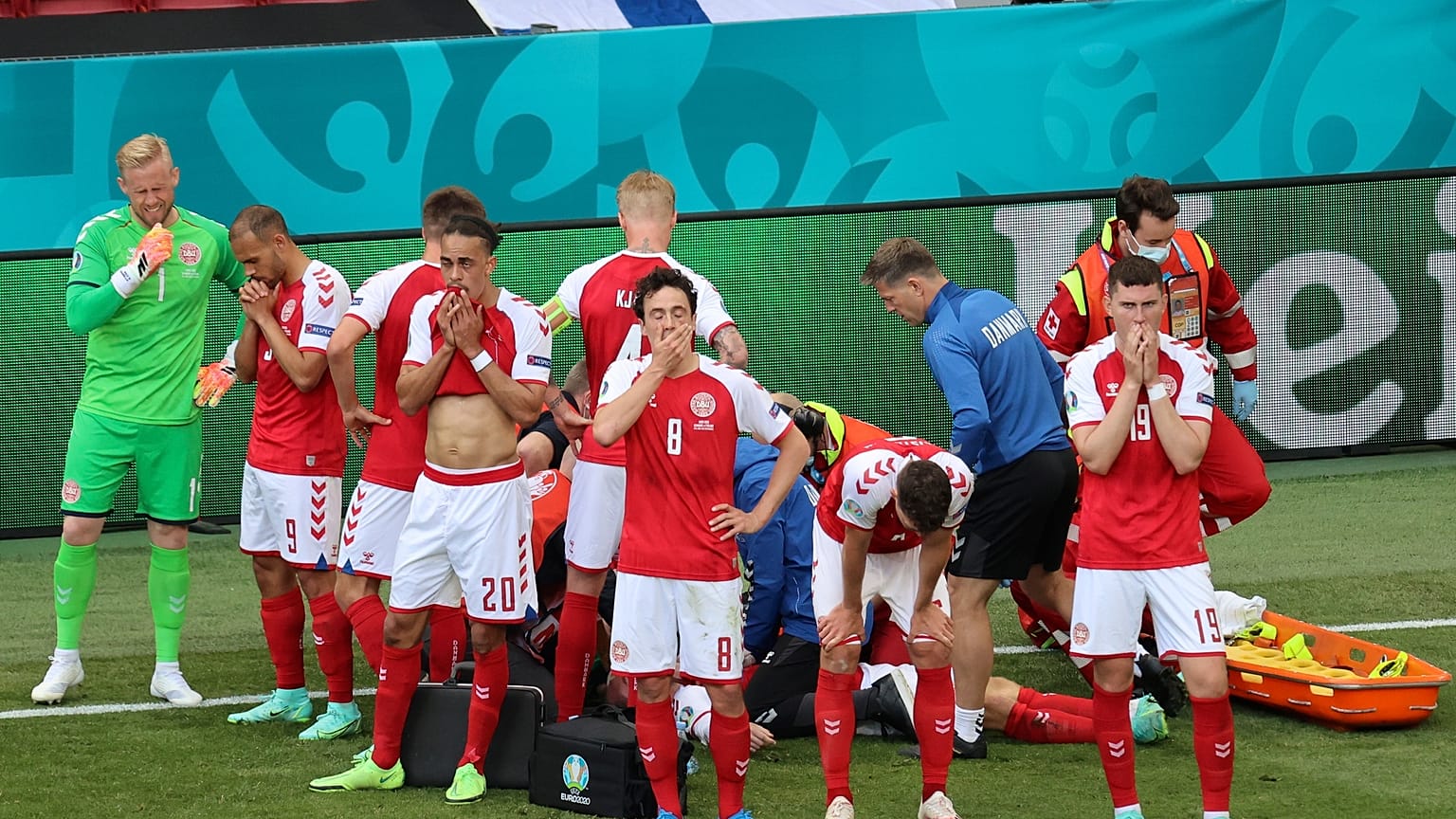 Denmark's players react as their teammate Christian Eriksen lays injured on the ground during the Euro 2020 soccer championship group B match between Denmark and Finland,
