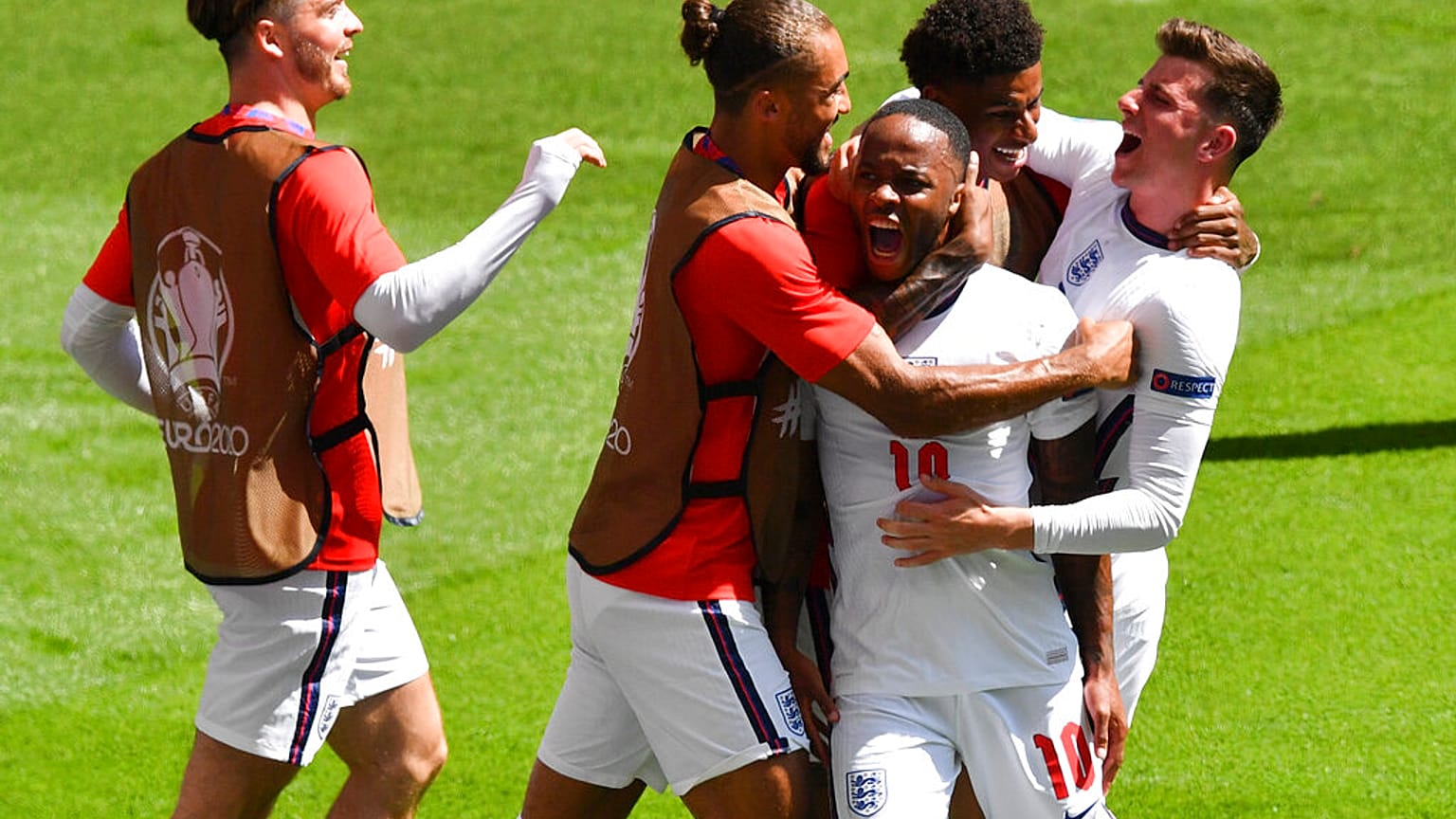 England's Raheem Sterling, centre, is congratulated by teammates after scoring his team's first goal during Euro 2020