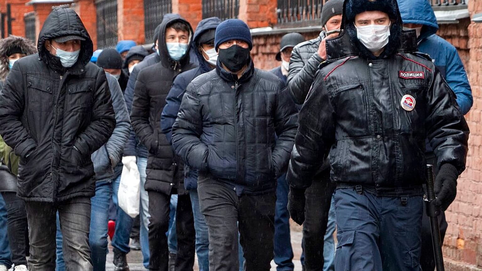 Полицейский сопровождает группу мигрантов. 