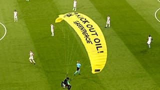 A Greenpeace paraglider lands at the Allianz Arena stadium in Munich prior to the Euro 2020 group F match between France and Germany, June 15, 2021