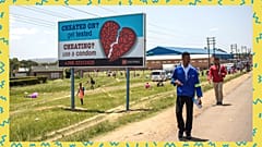 Des personnes passent devant un panneau d'affichage de sensibilisation de la AIDS Healthcare Foundation à Maputsoe, au Lesotho, le 31 janvier 2020
