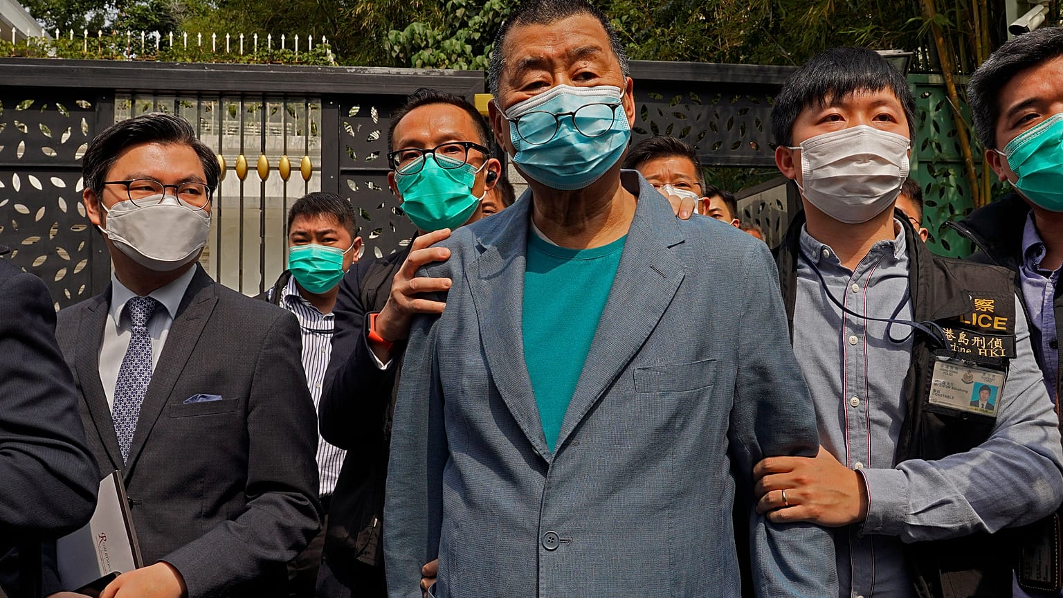FILE - In this April 18, 2020, file photo, Jimmy Lai, center, who founded newspaper Apple Daily, is arrested by police officers at his home in Hong Kong. 