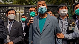 FILE - In this April 18, 2020, file photo, Jimmy Lai, center, who founded newspaper Apple Daily, is arrested by police officers at his home in Hong Kong.