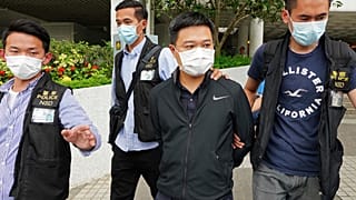 Ryan Law, second from right, Apple Daily's chief editor, is arrested by police officers in Hong Kong Thursday, June 17, 2021