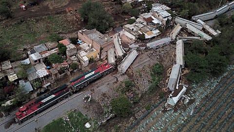 A freight train derailed and toppled onto houses alongside the tracks in western Mexico.